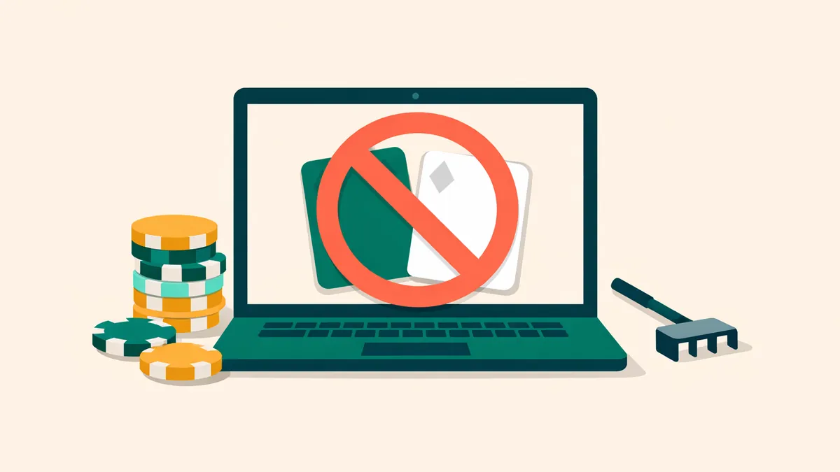 Laptop with playing cards under a prohibition sign, chips and a rake, illustrating the ban on real money online poker